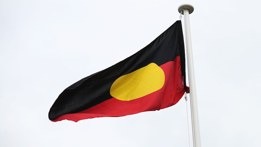 The Aboriginal flag set against a clear sky.