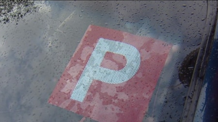 Picture of a car windscreen with a p-plate on it.