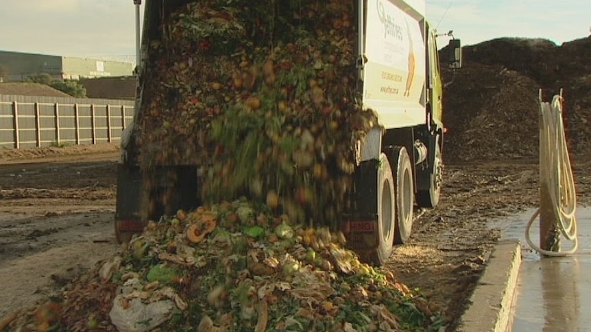 A truck tips out a load of fruit and vegetables