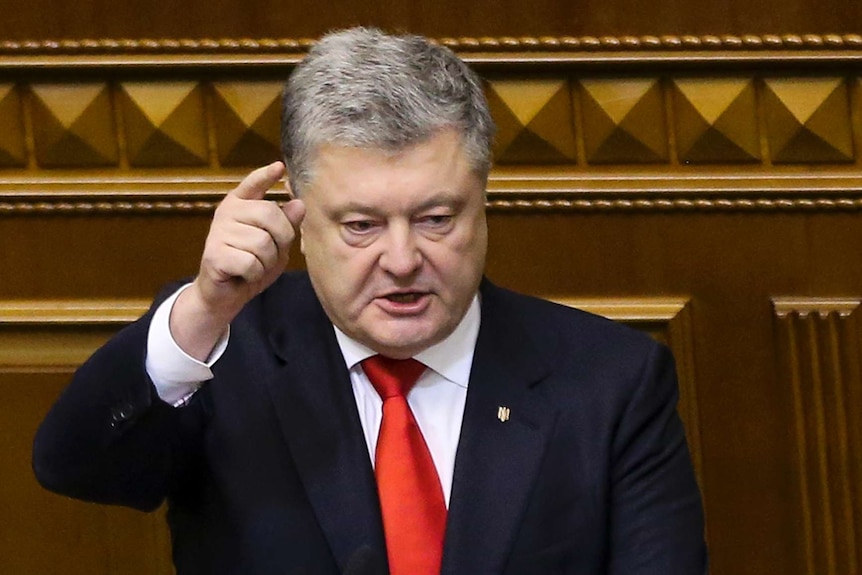 Petro Poroshenko raises a finger to point during a session in parliament