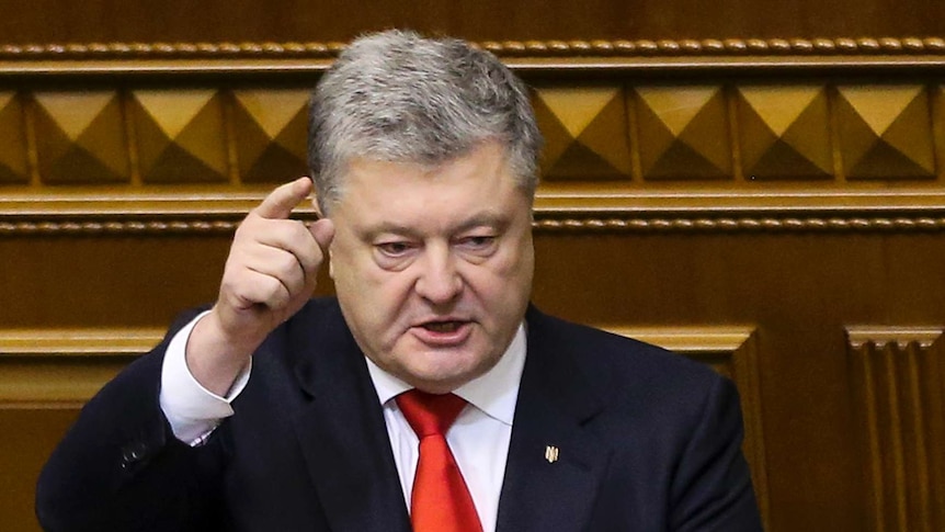 Petro Poroshenko raises a finger to point during a session in parliament