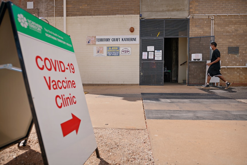 The outside of a COVID-19 vaccination clinic in Katherine, with a sign pointing to the entry in the foreground.