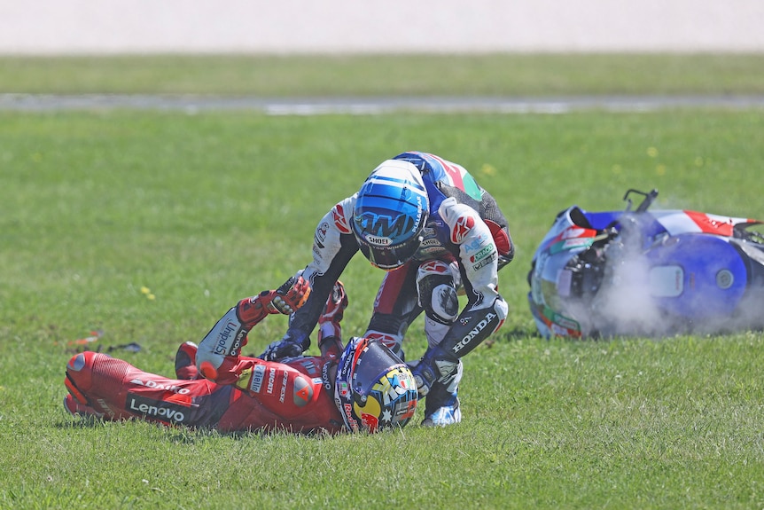 Alex Marquez leans over Jack Miller who is lying on his back