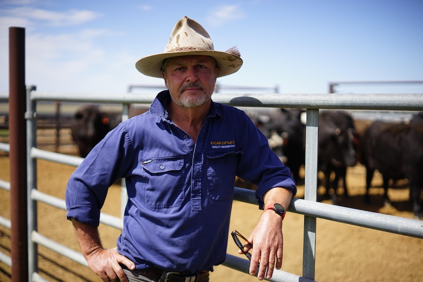 A man stands in a feed lot and smiles 