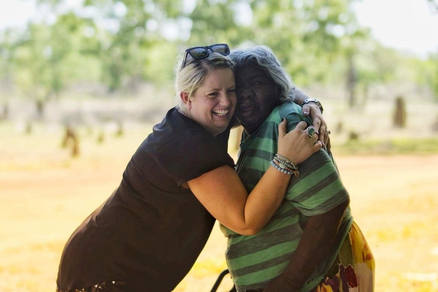 Ms Wright (left) hugging indigenous elder in Jilkminggan community.