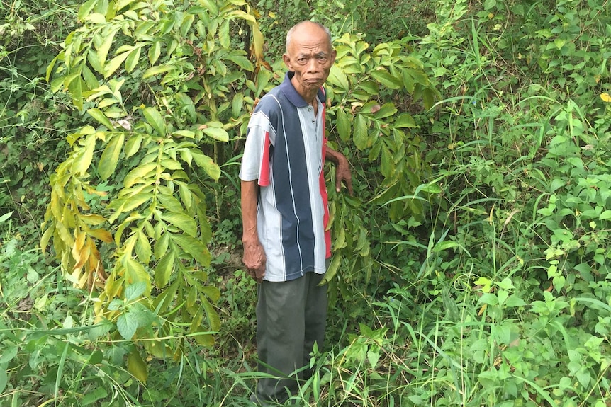 Villager Radimin stands in unused grave