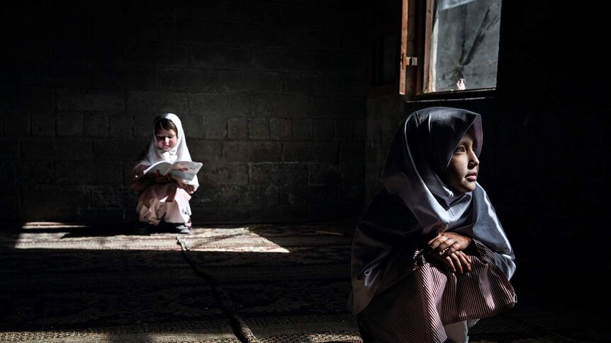 A photograph of two girls in a house in Pakistan by Photographer Andrea Francolini.