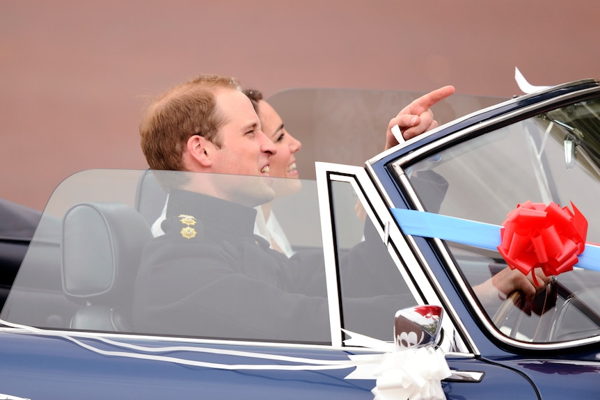 A close up of Prince William and Kate in a car, Kate in her wedding dress and William in a black suit