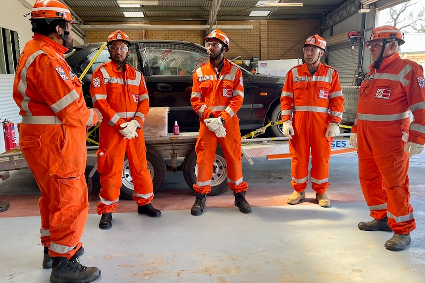 SES team members standing in a circle in orange high visibility uniforms