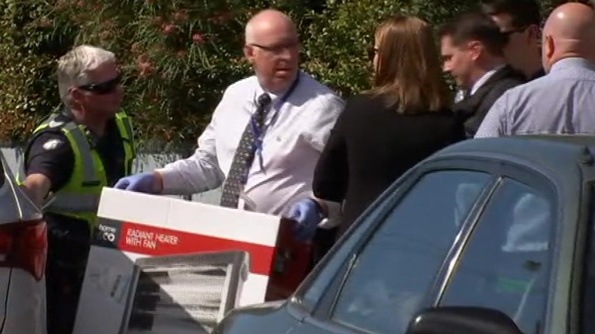 Investigators place a heater box in a car.