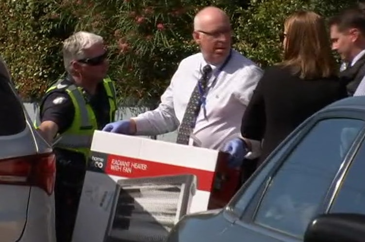 Investigators place a heater box in a car.