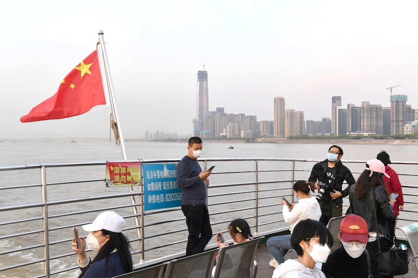 Passengers wearing face masks ride a ferry on the Yangtze River