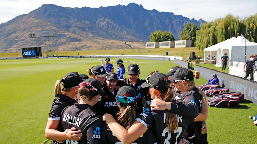 The White Ferns huddle with a mountain range in the background in Queenstown