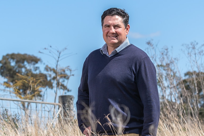 A man stands in a grassy field