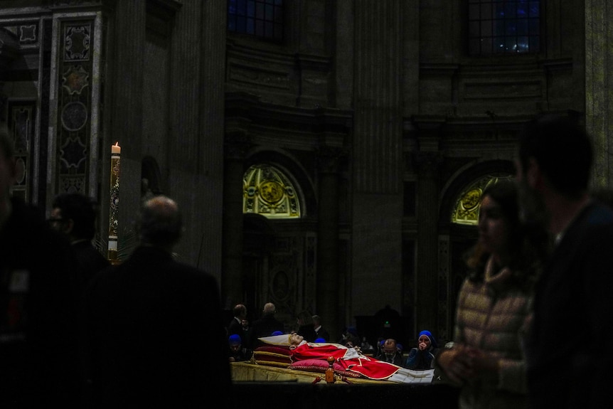 People walk past as the body of the late Pope Emeritus Benedict XVI lies in state.
