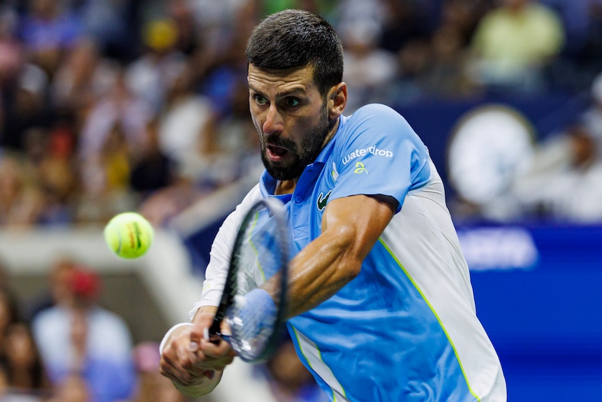 Novak Djokovic plays a double-fisted backhand at the US Open.