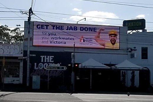 A billboard promoting vaccinations to construction workers. 