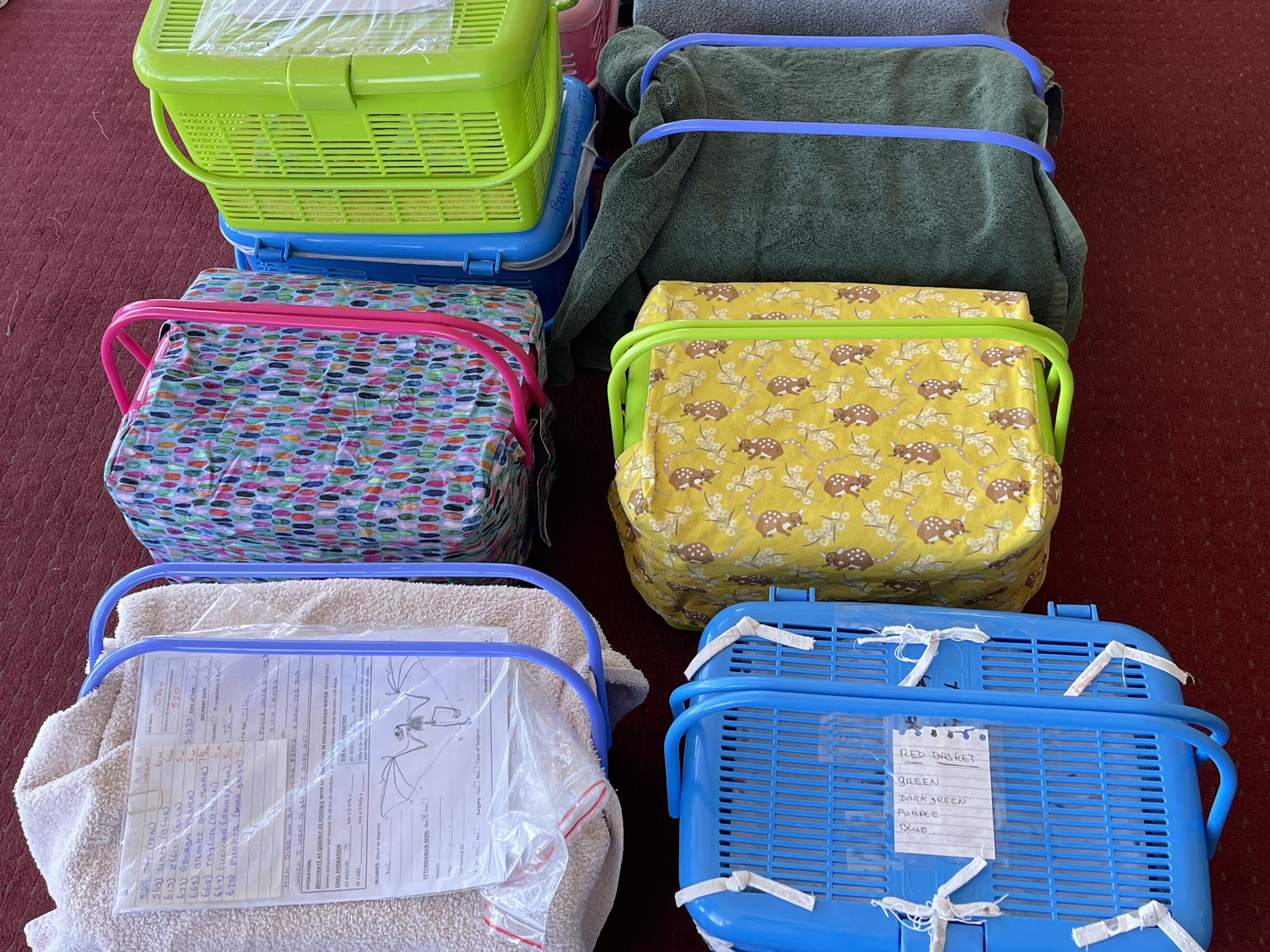 Eight baskets covered in fabric on the floor. 