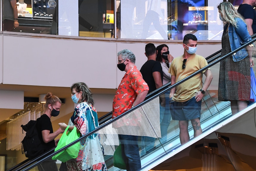 People wearing face masks on an escalator