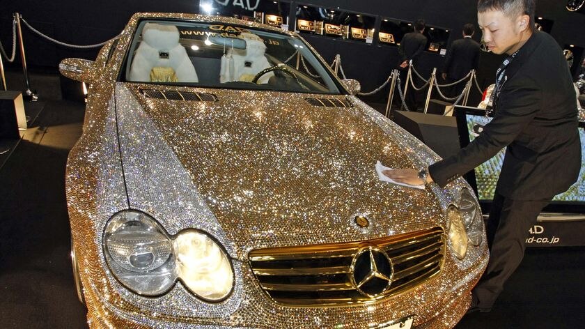 An exhibitor polishes a customised Mercedes-Benz SL600 studded with 300,000 Swarovski crystal glass