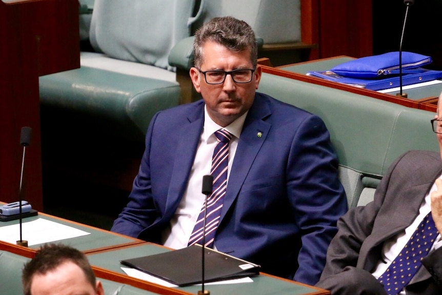 Man in a suit sitting in the House of Representatives