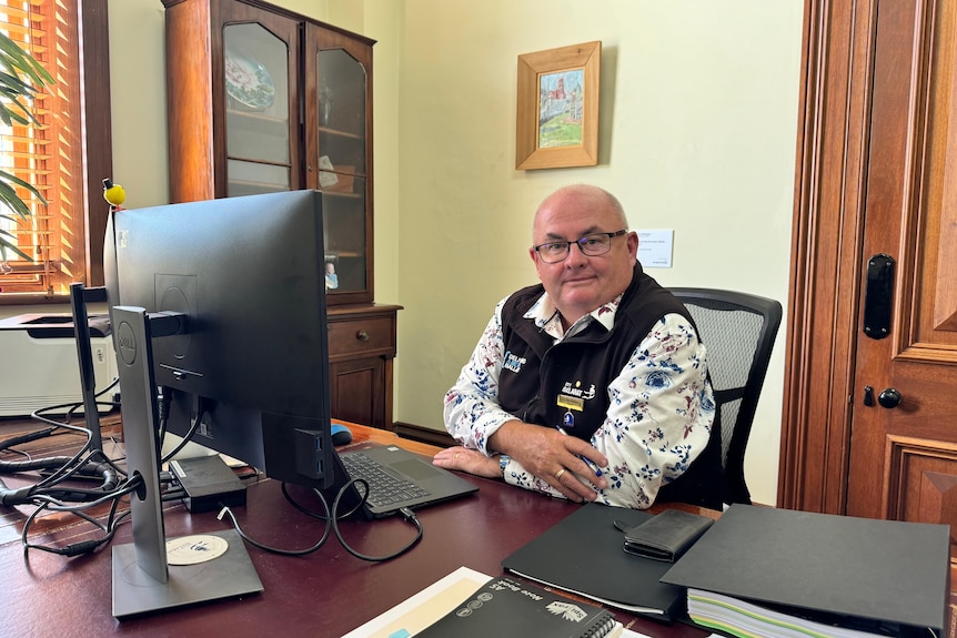 ballarat mayor des hudson gently smiling while sitting at desk in town hall