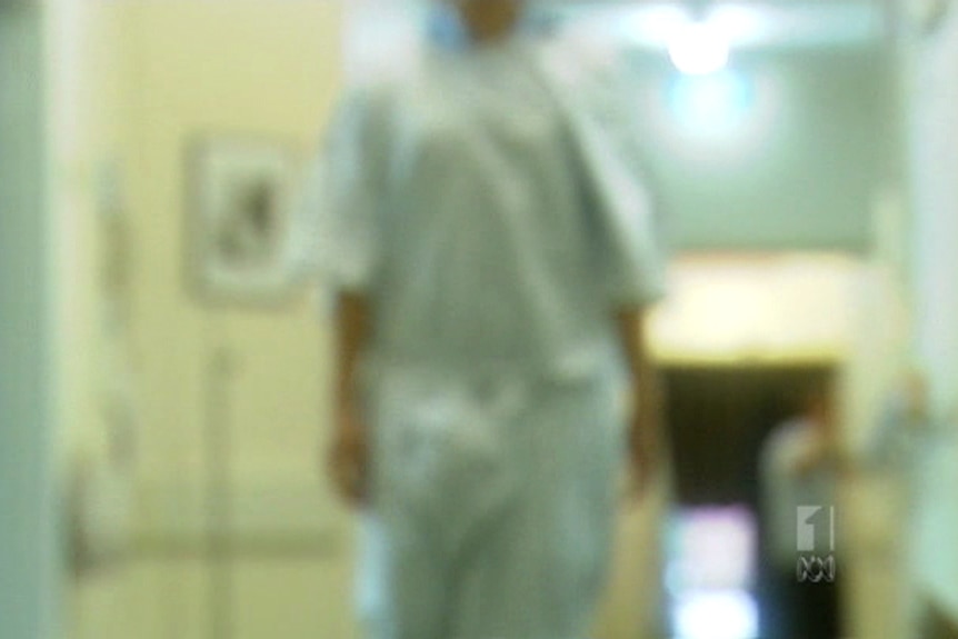 Blurred image of a person walking in a hospital gown.