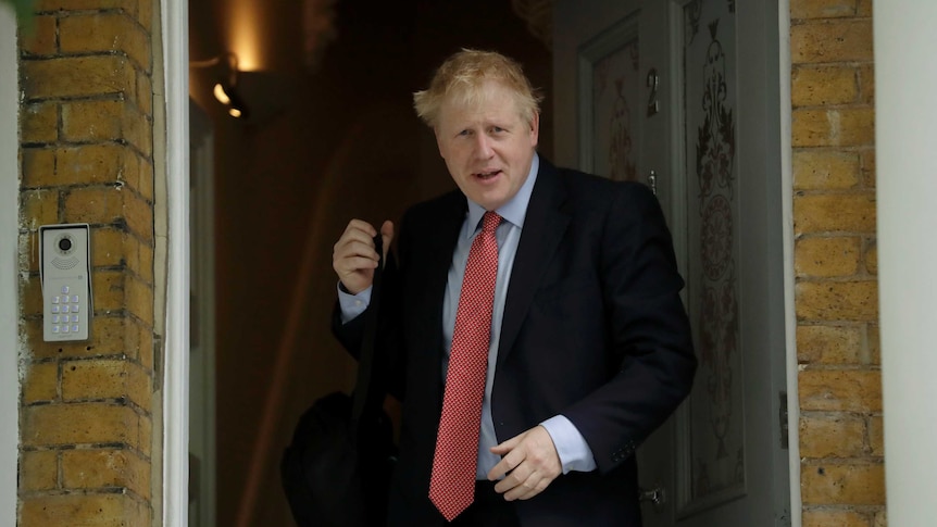 British MP Boris Johnson stands in the door way of his London home