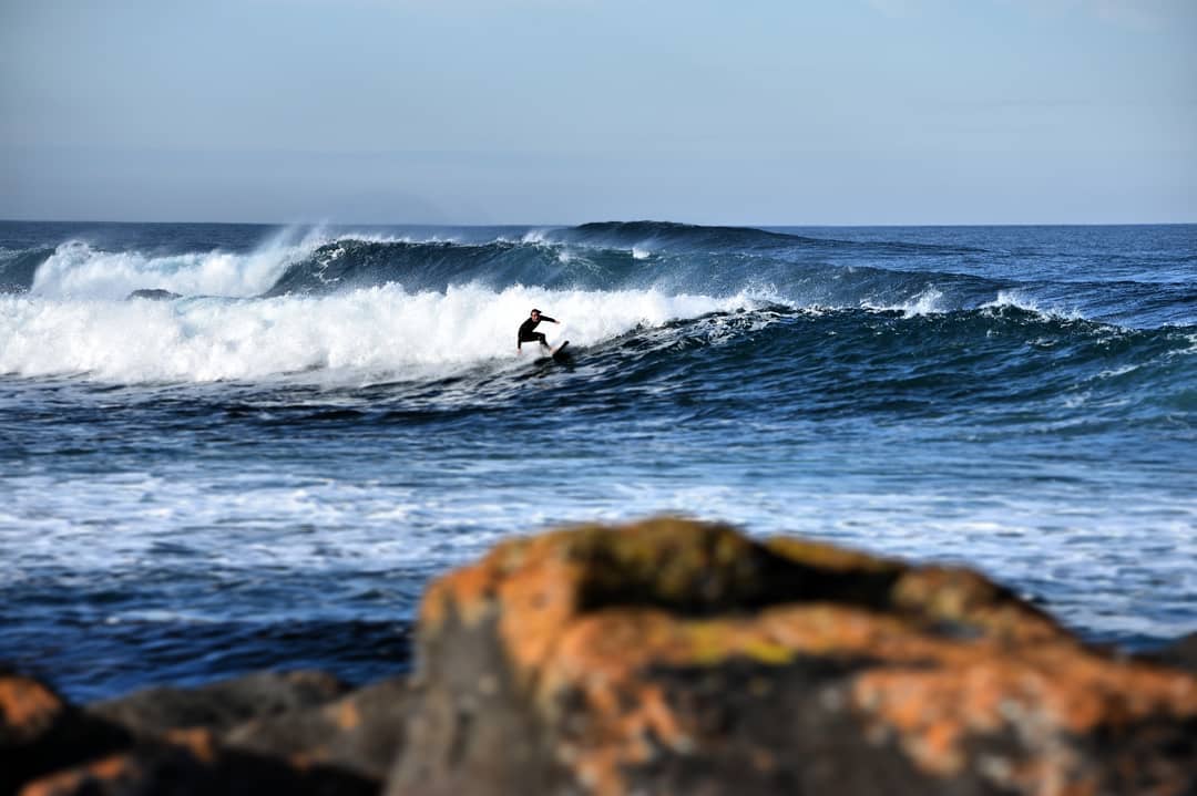 surfer with rocks in front