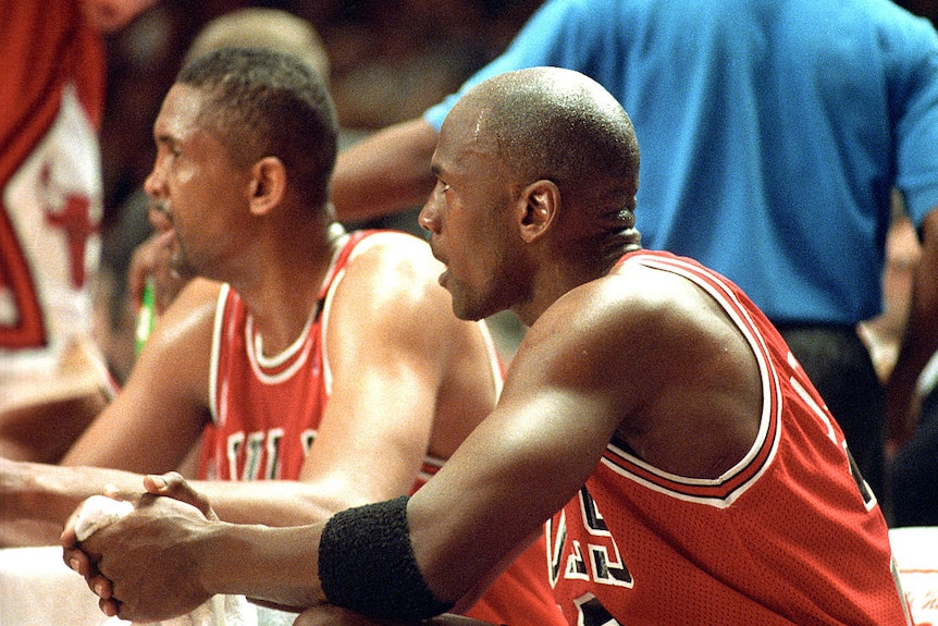 A young Bill Cartwright sits next to Michael Jordan on the bench during a Chicago Bulls vs New York Knicks game in 1993