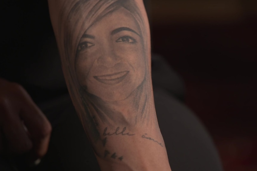 A tattoo of a woman's face on someone's arm.