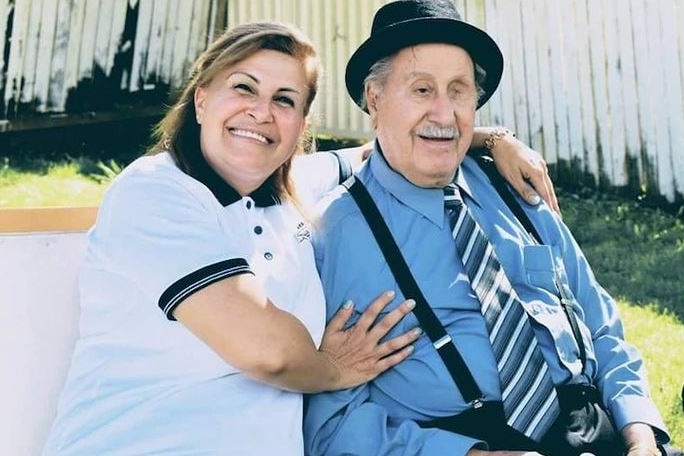 a woman hugging an elderly man