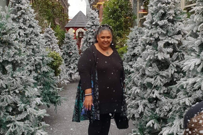 A woman among some snowy trees, wearing all black