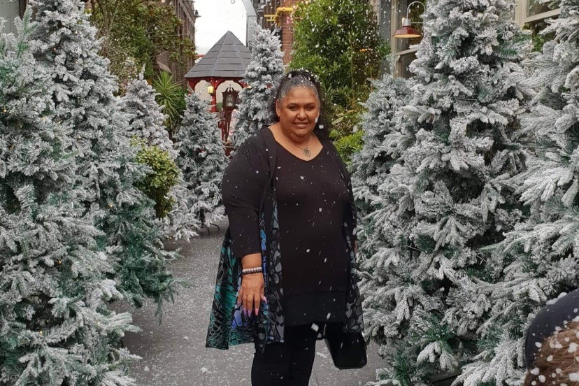 A woman among some snowy trees, wearing all black