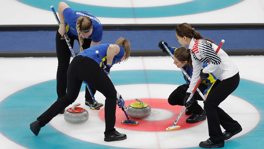 Three Sweden players and one South Korean sweep during curling final.