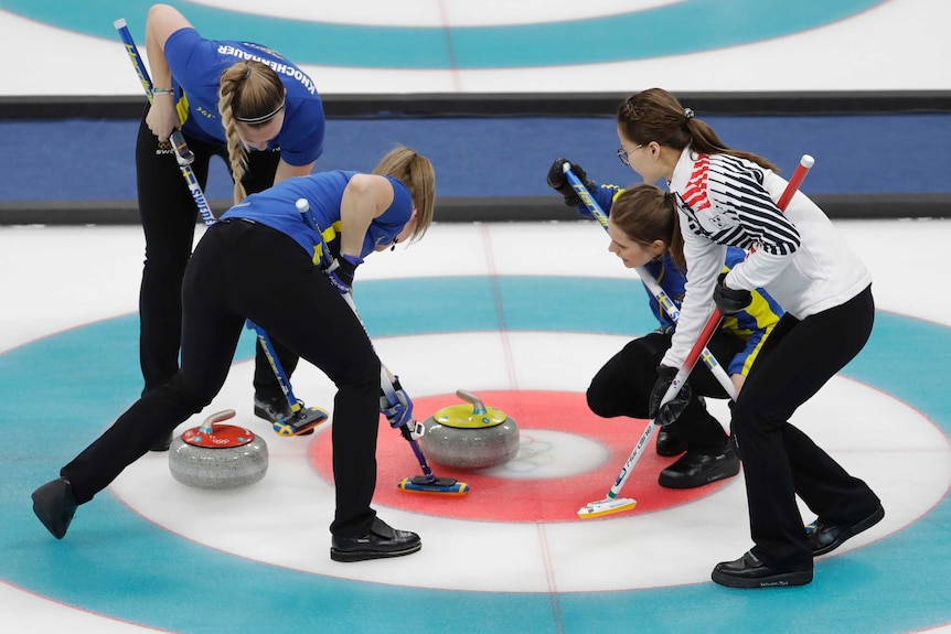 Three Sweden players and one South Korean sweep during curling final.