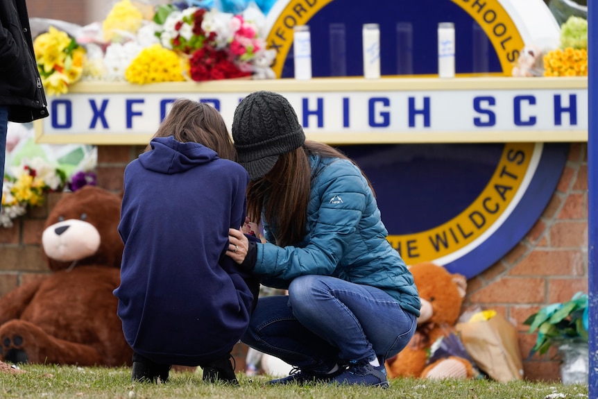 Mourners grieve at an Oxford High School memorial.