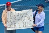 John McEnroe and Martina Navratilova stand holding a sign that says "Evonne Goolagong Arena".
