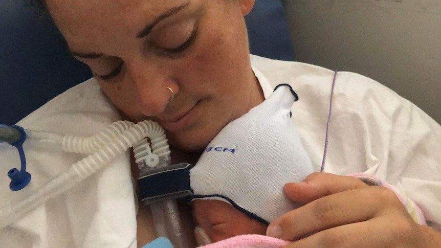 Abbey Leggett holds her newborn baby.