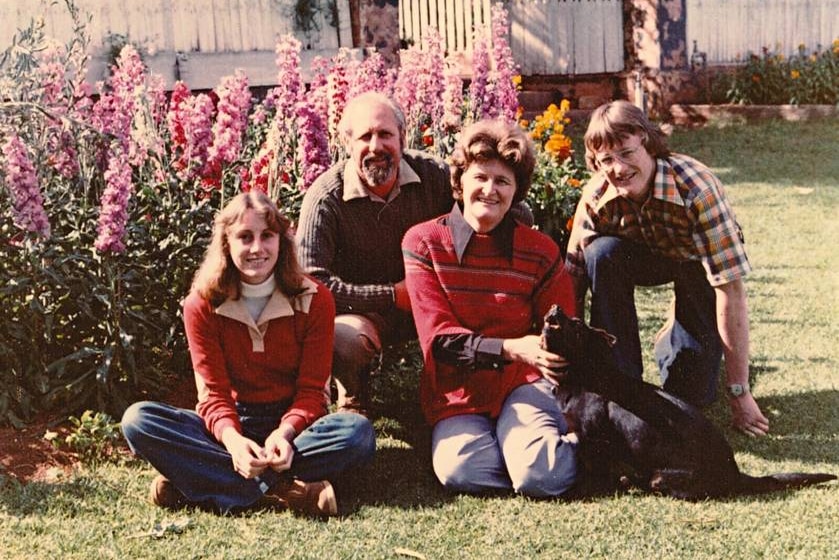 the Reid family posing in front of their house with their dog. 