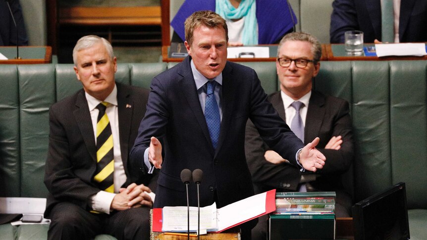 Christian Porter gestures with both hands towards the opposition in Question Time