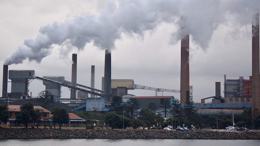 Image of steel works with plumes of steam.