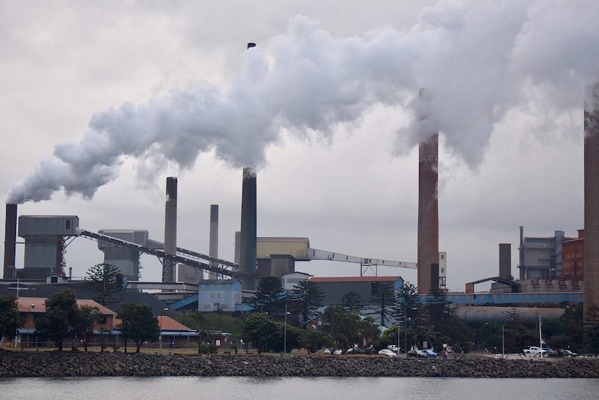 Image of steel works with plumes of steam.