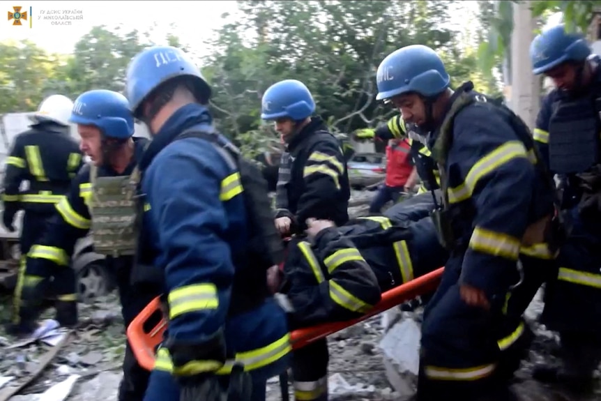 Rescuers evacuate a person from a residential building hit by a Russian military strike