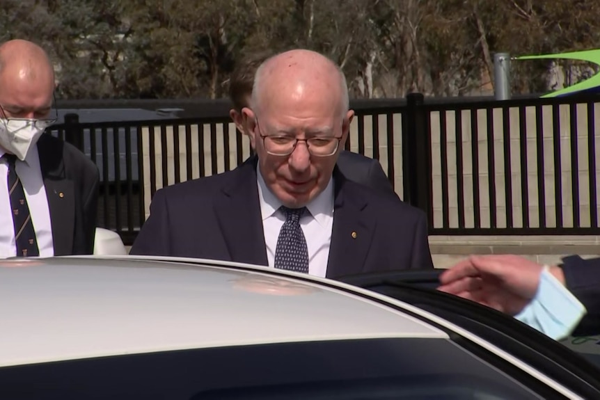 The Governor-General David Hurley wearing a suit and tie hops into a white car in Canberra.