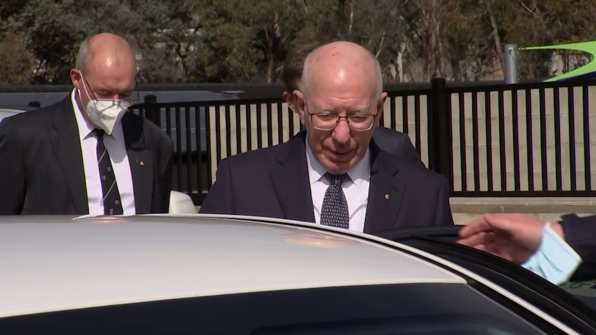 The Governor-General David Hurley wearing a suit and tie hops into a white car in Canberra.