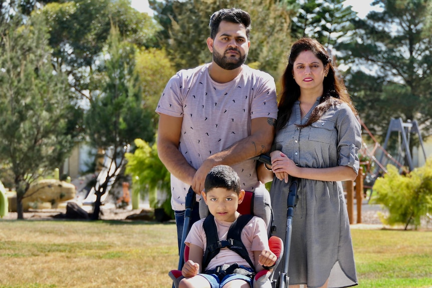 Varun and Priyanka Katyal standing in a park behind their son Kayaan.