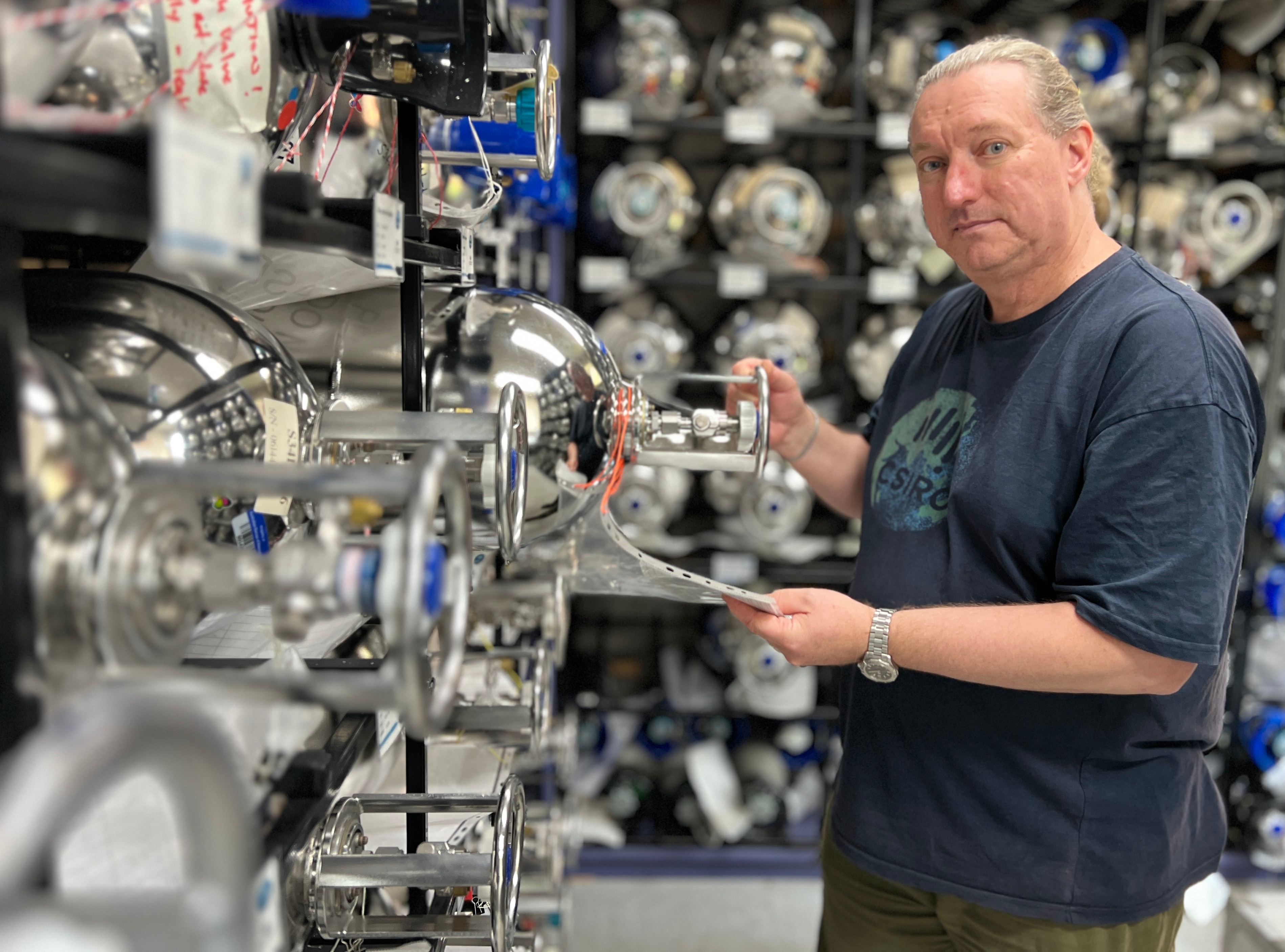 A man stands in front of air tanks