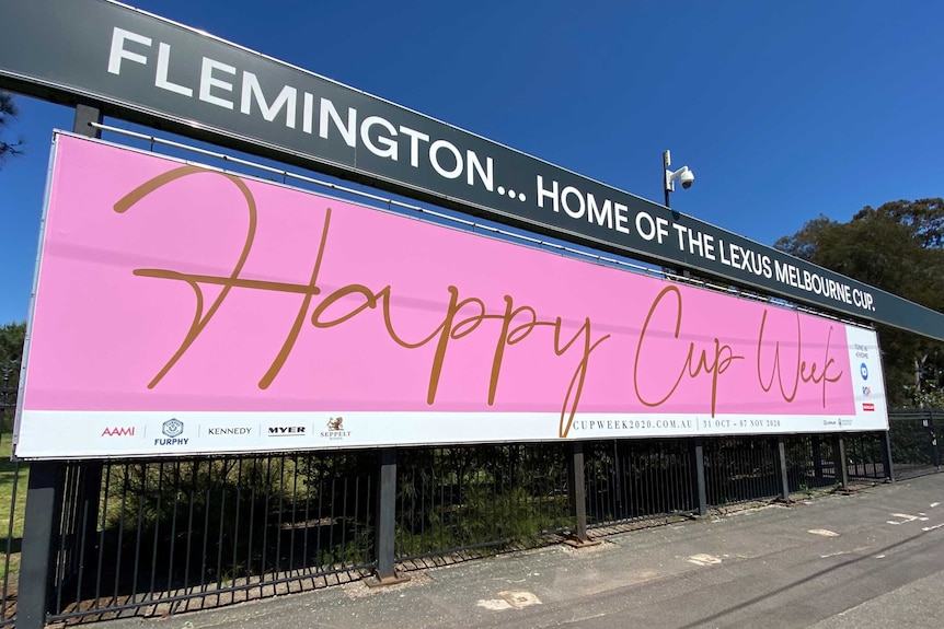 A large pink sign at Flemington Racecourse saying Happy Cup Week.