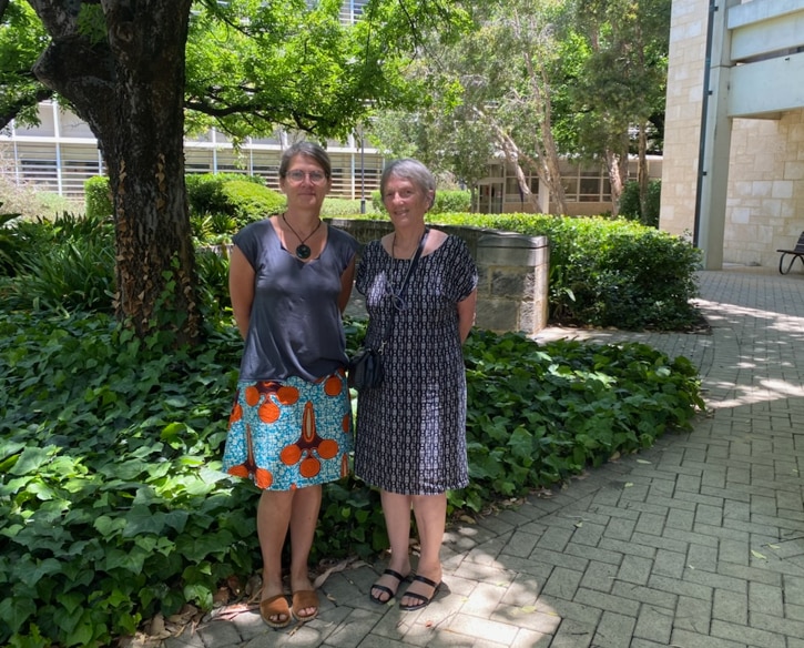 Un plano general de dos mujeres frente a un jardín.